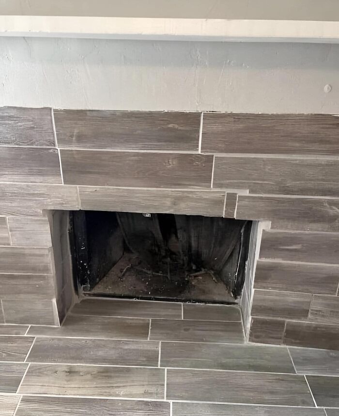 Cheap construction fail with misaligned tile placement around a fireplace opening.