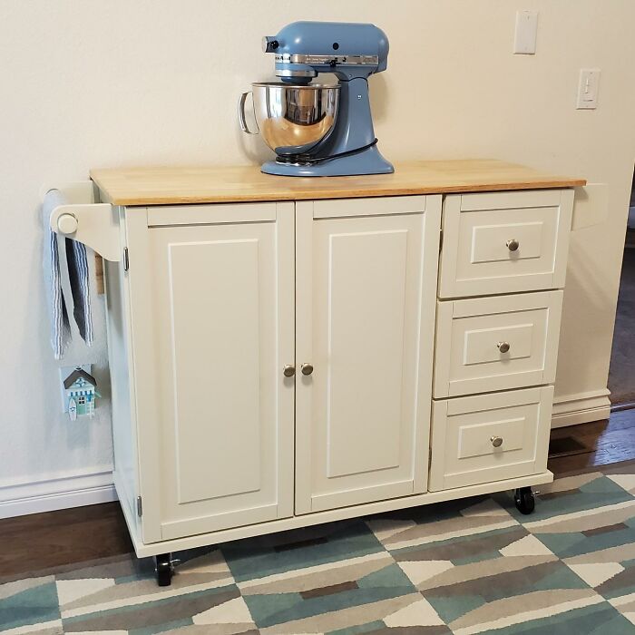 Cream kitchen cart with a blue mixer on top, showcasing organization tips.