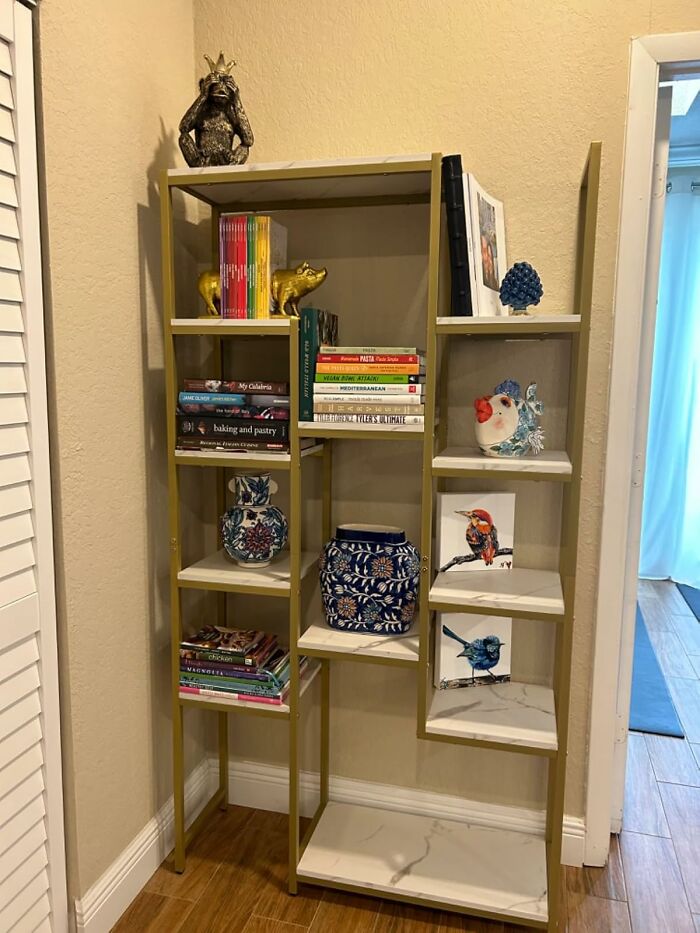 Gold and white bookshelf with decorative items and books, showcasing Amazon furniture with excellent reviews.