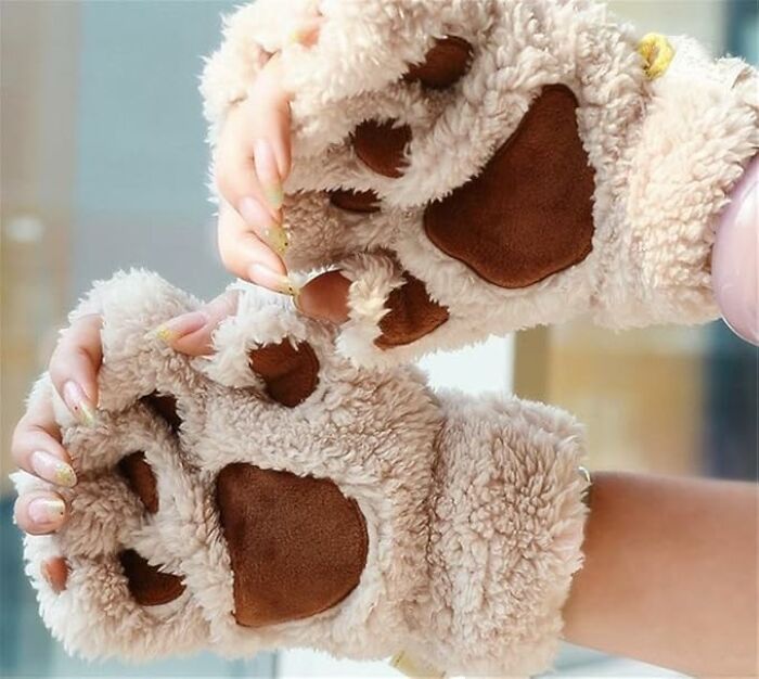 Fuzzy bear paw gloves worn on hands, featuring brown paw pads, an item among cool things we covet.