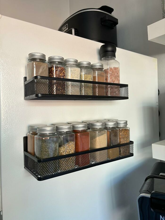 Spice jars neatly organized on kitchen shelves, improving organization and accessibility.