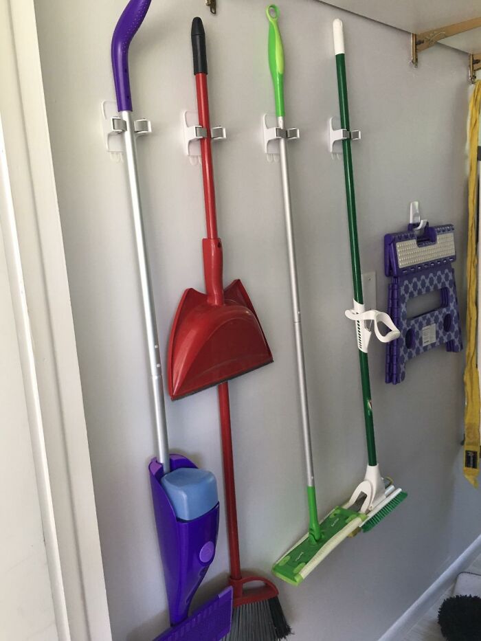 Cleaning tools neatly organized on wall hooks, showcasing efficient organization.