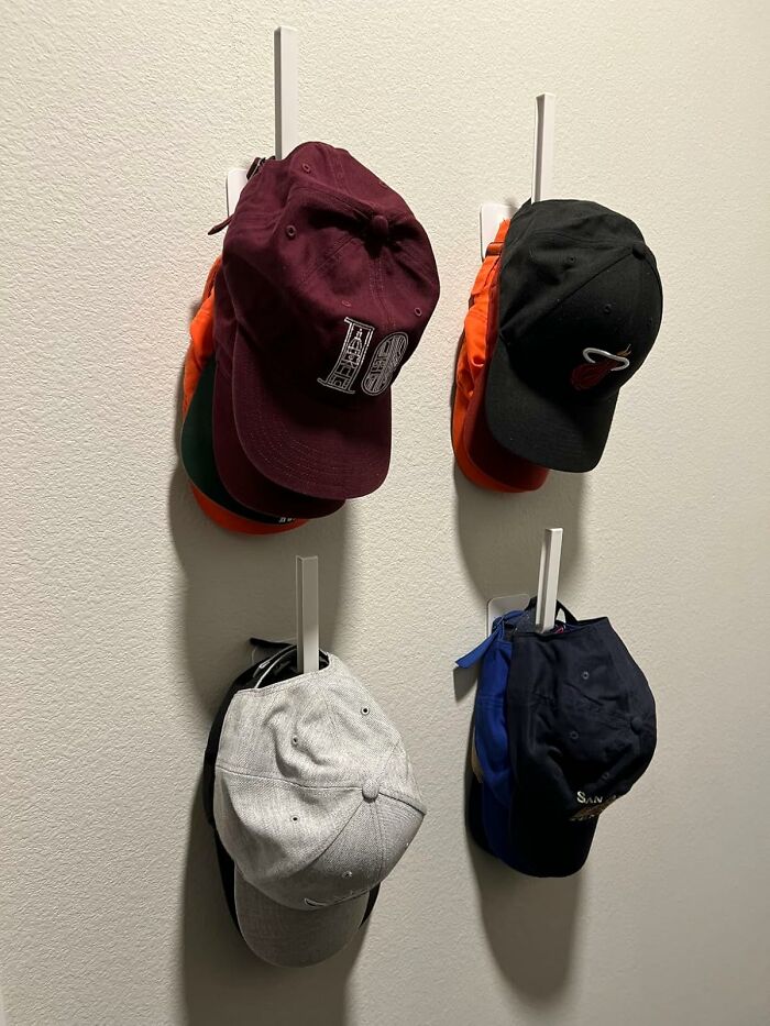 Wall-mounted hat organizer with neatly arranged caps, illustrating a new way to organize effectively.