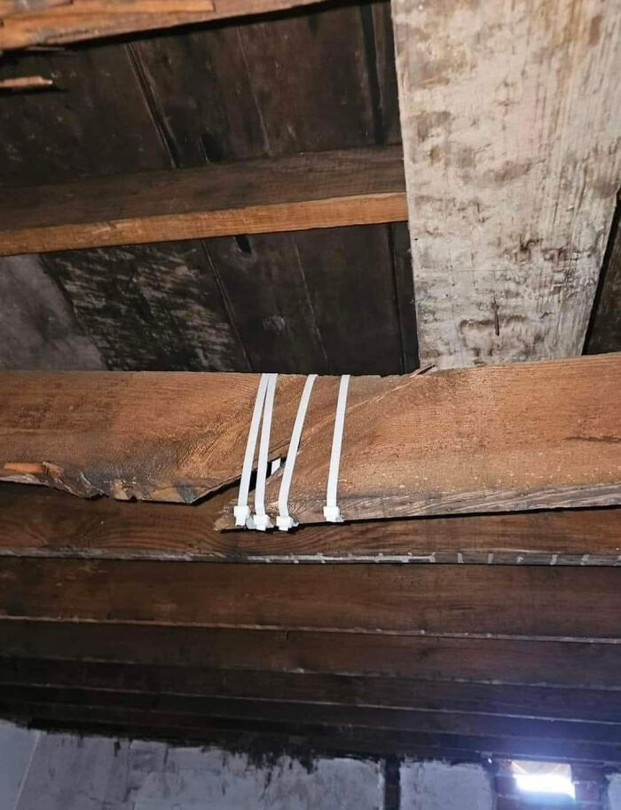 Wooden beam secured with zip ties, showcasing a funny construction fail.