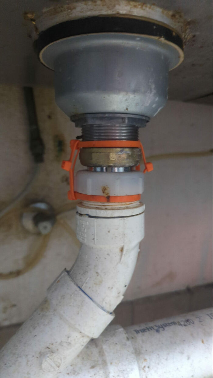 Funny cheap construction fail with makeshift pipe repair under a sink.