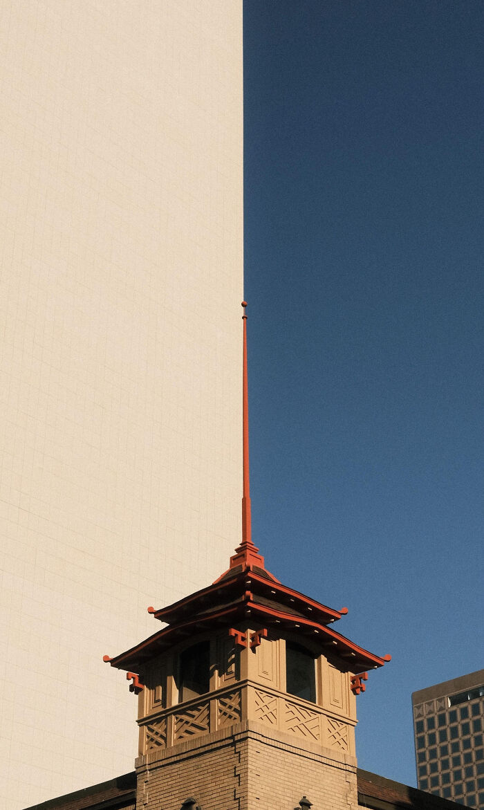 Incredible World Photo of a historic building with a red ornate roof against a backdrop of contrasting modern architecture.