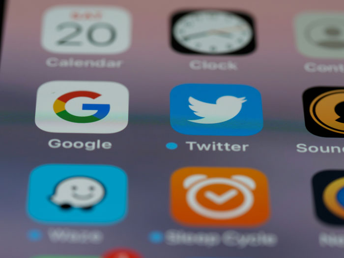 Close-up of smartphone apps, including Twitter and Google, relevant to Gen A's digital habits.