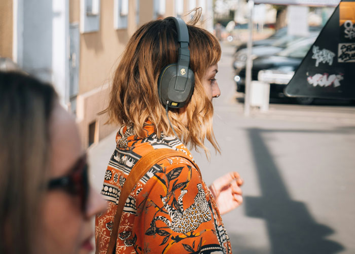 Person in patterned attire outdoors, wearing headphones, exemplifying popular security measures for personal safety.