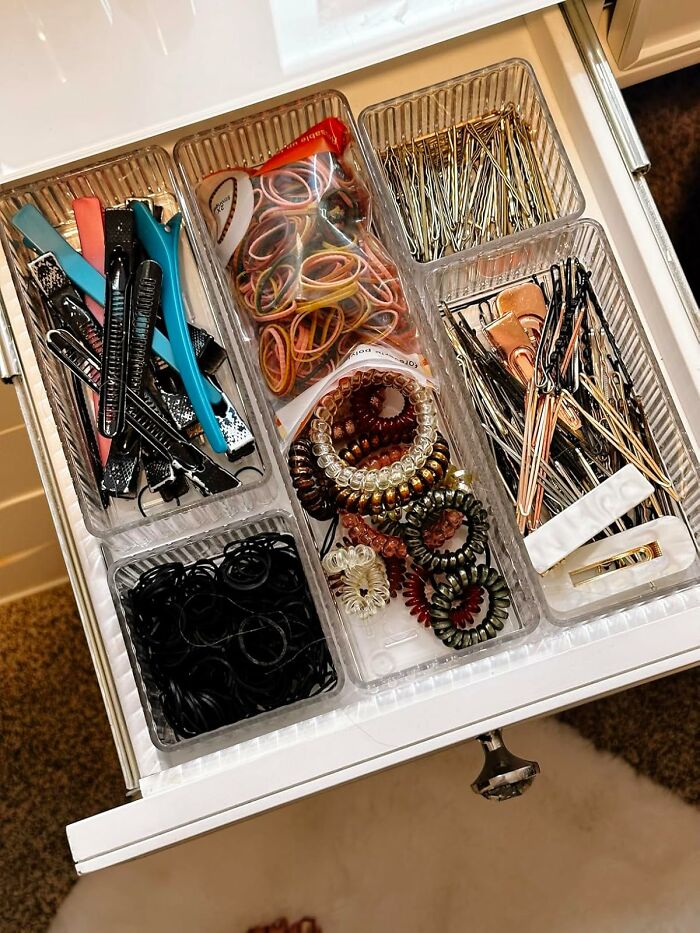 Drawer neatly organized with clips, bands, and pins, showcasing efficient organization techniques.