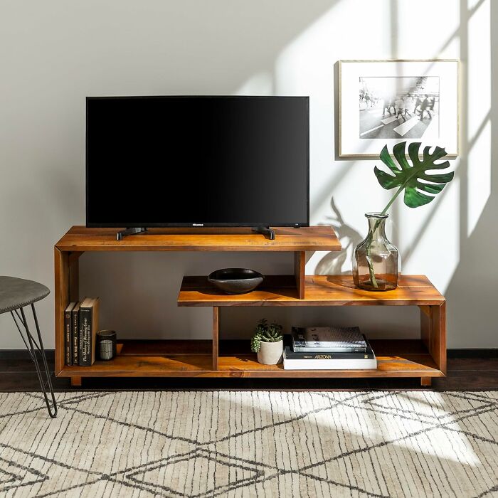 Modern wooden TV stand with books and decor, highly rated on Amazon furniture.