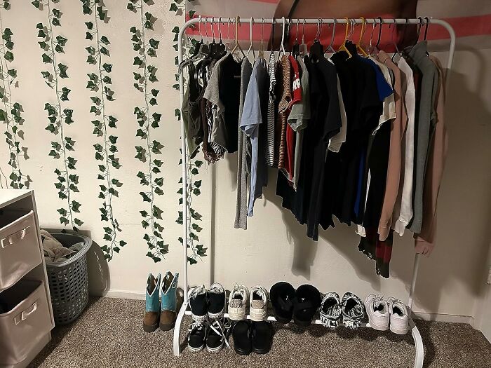 Clothing rack with organized shirts and shoes in a tidy room.