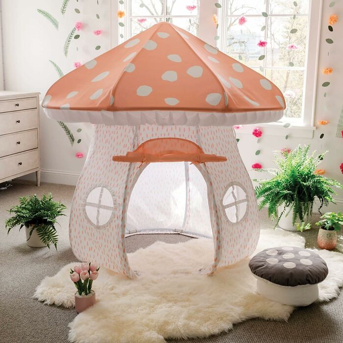 Whimsical mushroom-shaped play tent in a cozy room with plush decor and plants, epitomizing coolest things we covet.