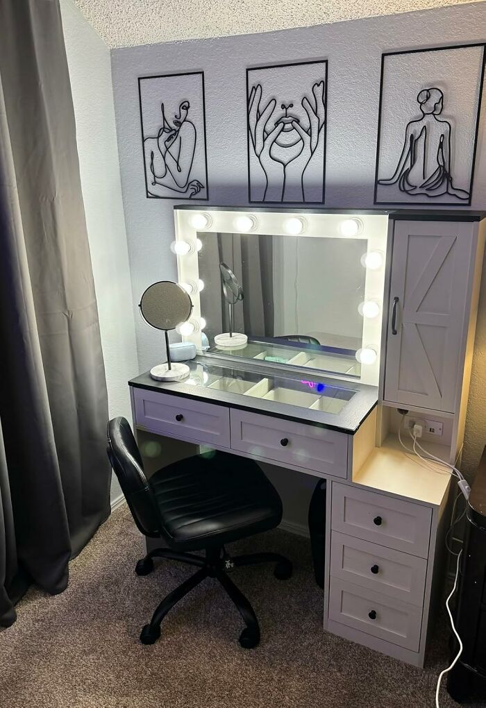 Vanity desk with mirror and lights, black chair, modern wall art; excellent reviews on Amazon furniture.