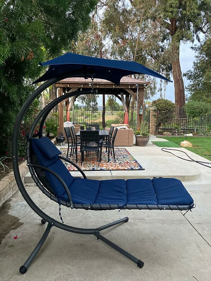 Outdoor lounge chair with canopy in a garden, part of Amazon furniture with excellent reviews.