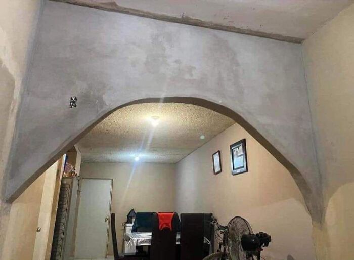 Amateur archway in a living room shows a classic cheap construction fail with uneven design and finish.