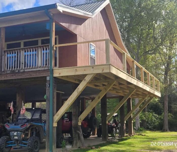 Uneven wooden balcony with steep supports, highlighting funny construction fails in a rural setting.