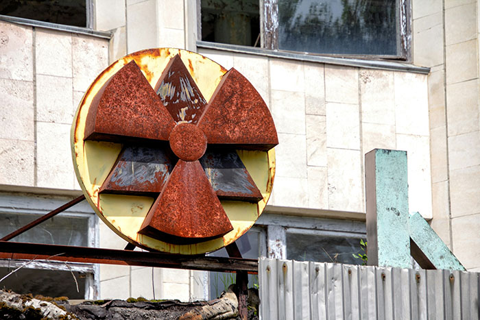 Rusty radioactive symbol near Chornobyl, highlighting genetic differences in dogs from the area.