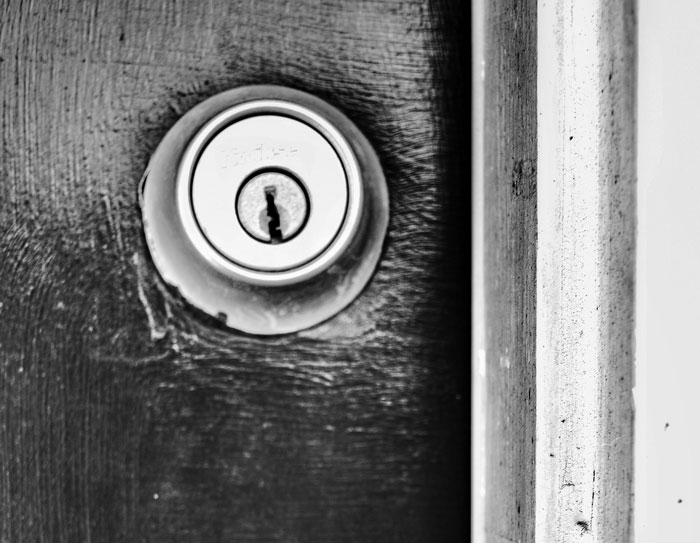 Black and white image of a secure door lock, highlighting importance of security measures.