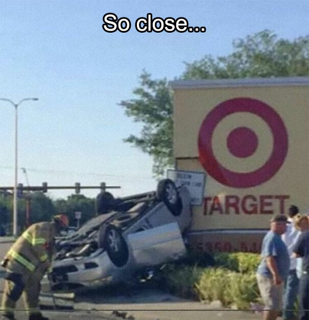 Overturned car humorously crashes by Target sign, capturing an absurd sign scene.