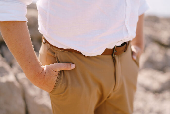 Person in khaki pants and a white shirt with hands in pockets, illustrating the concept of HR not being your friend.