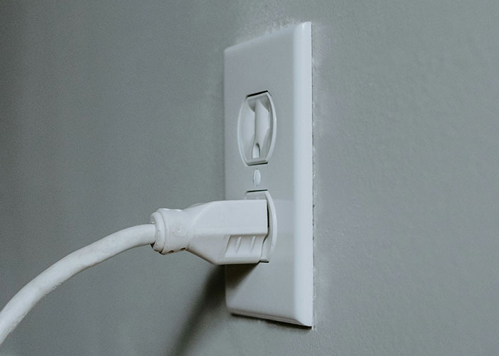 Electrical plug partially inserted into a wall socket, capturing a wild 911 call scenario.