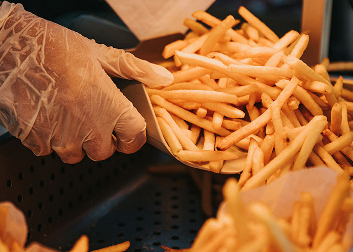 Gloved hand serving french fries from a fryer, highlighting unexpected moments in dispatcher memories.