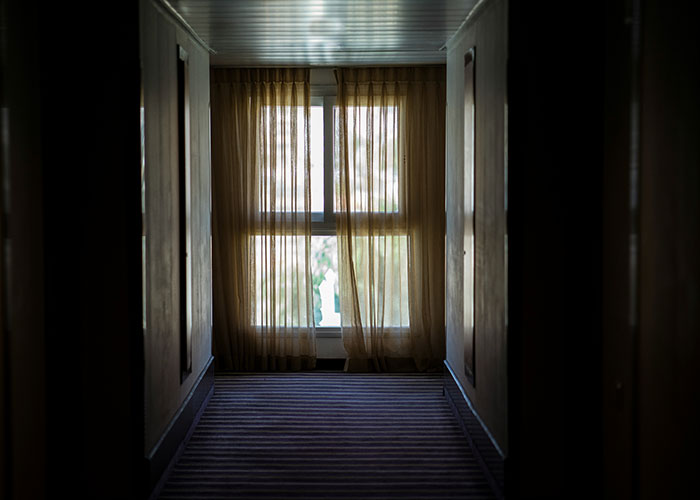 Dimly lit hallway with closed curtains, creating a mysterious atmosphere related to wild 911 calls.