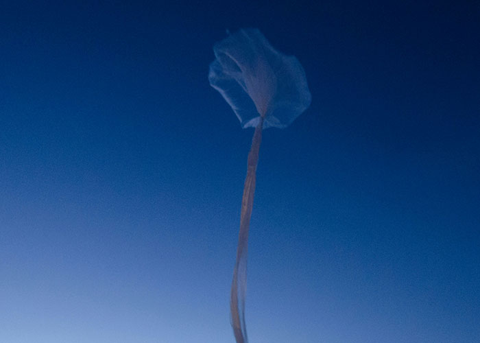 A plastic bag drifts against a deep blue sky, symbolizing wild 911 call memories for dispatchers.