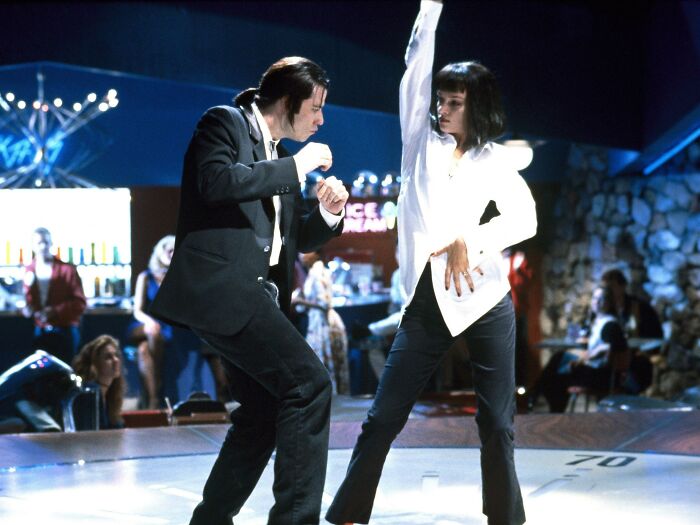 Two characters dance energetically under bright lights, evoking fascinating fan theories about their iconic scene.