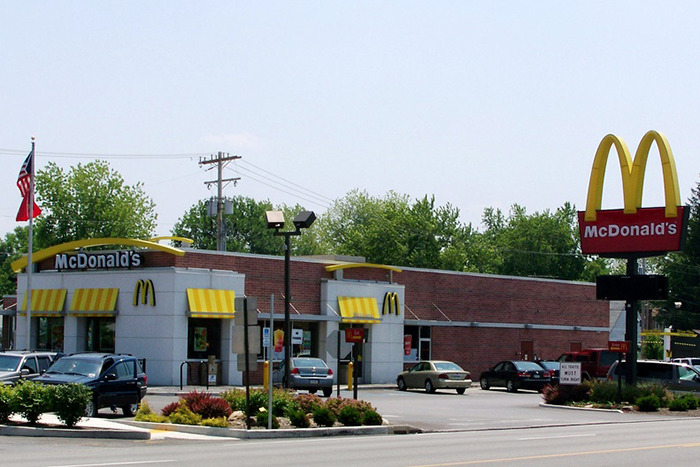 Exterior of McDonald's restaurant with cars in the parking lot.