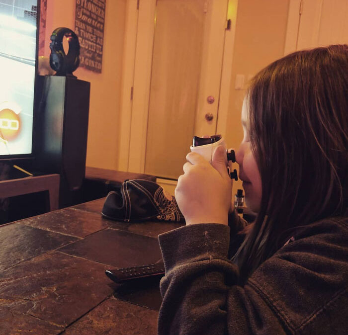 Child using a binocular casing on a gaming controller as a Parenting-Genius-Trick to focus on the screen.