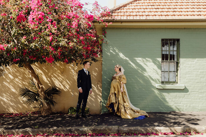 Bride and groom in elegant attire under bougainvillea, showcasing top wedding photo trends of 2024.