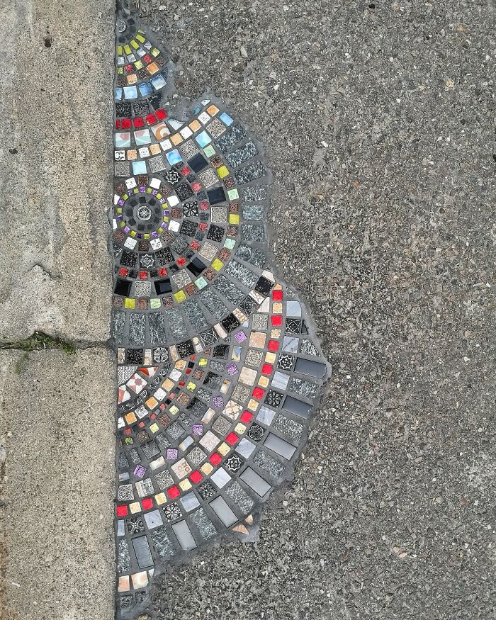 Vibrant mosaic art mending a cracked sidewalk with colorful tiles and patterns.