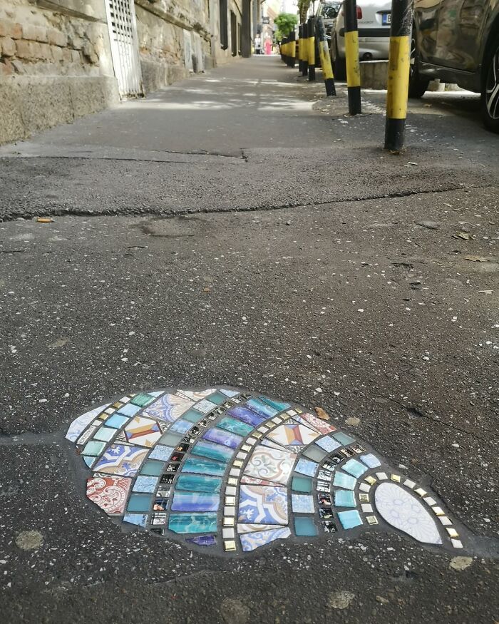 Vibrant mosaics repair a cracked sidewalk, showcasing colorful tiles and artistic restoration.