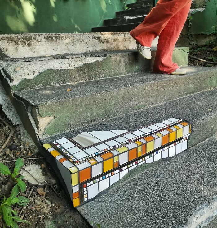 Vibrant mosaic art mends cracked sidewalk step.