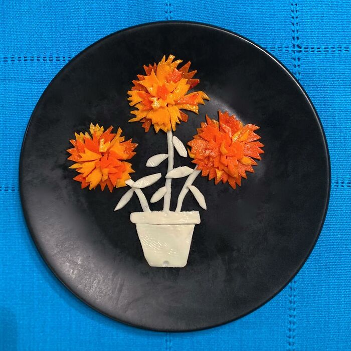 Artistically fried eggs arranged as flowers on a black plate.