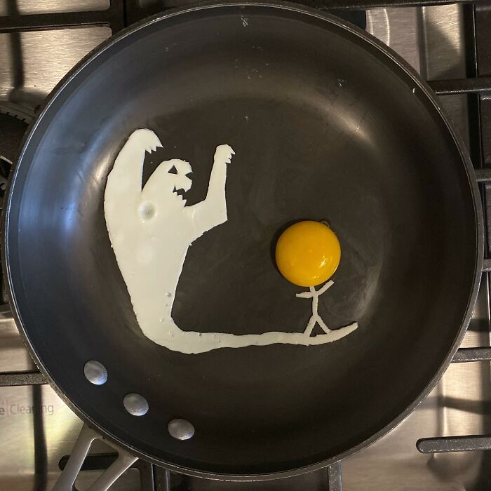 Creative fried egg art depicting a ghostly figure and a stick figure in a pan.