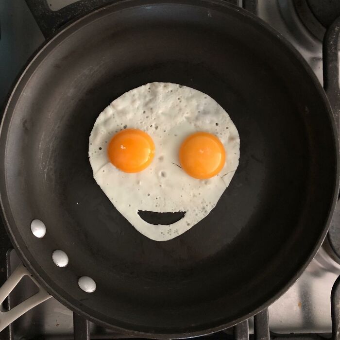 Creative way fried eggs look like a face in a pan.