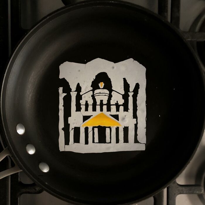 Creative fried eggs resembling a cathedral in a black pan.