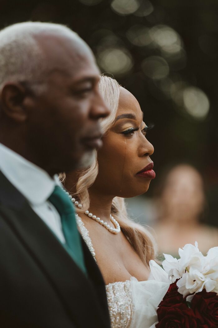 Emotional wedding moment with a bride holding flowers and shedding tears, capturing one of the top wedding photos of 2024.