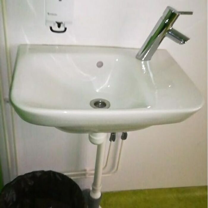 Construction fail: faucet misaligned with sink basin, humor in design.