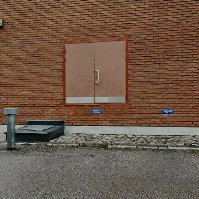 Construction fail with door installed in brick wall, leading nowhere, highlighting worker mistakes.