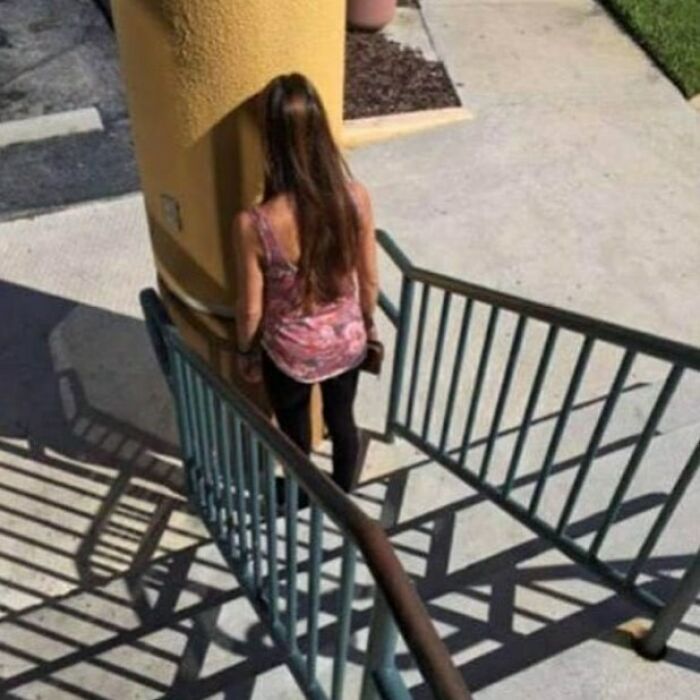 Construction fail: a woman encounters a pole blocking stairs, illustrating comical error in planning.