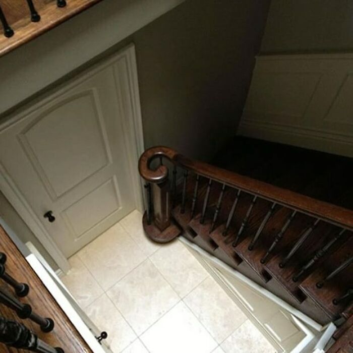 Staircase humorously built in front of a door, showcasing construction workers' error.