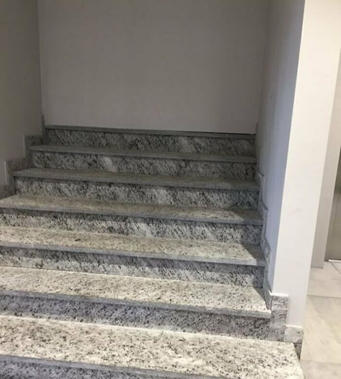 Marble stairs built directly into a wall, showcasing a construction fail.