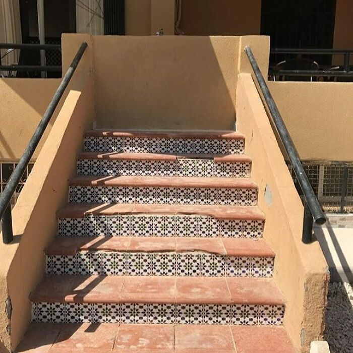 Uneven construction stairs mishap with misaligned tiles and railings.