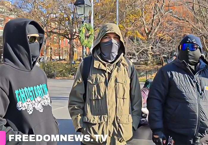 Three people in masks and hoodies outdoors, related to Brian Thompson homicide lookalike contest.