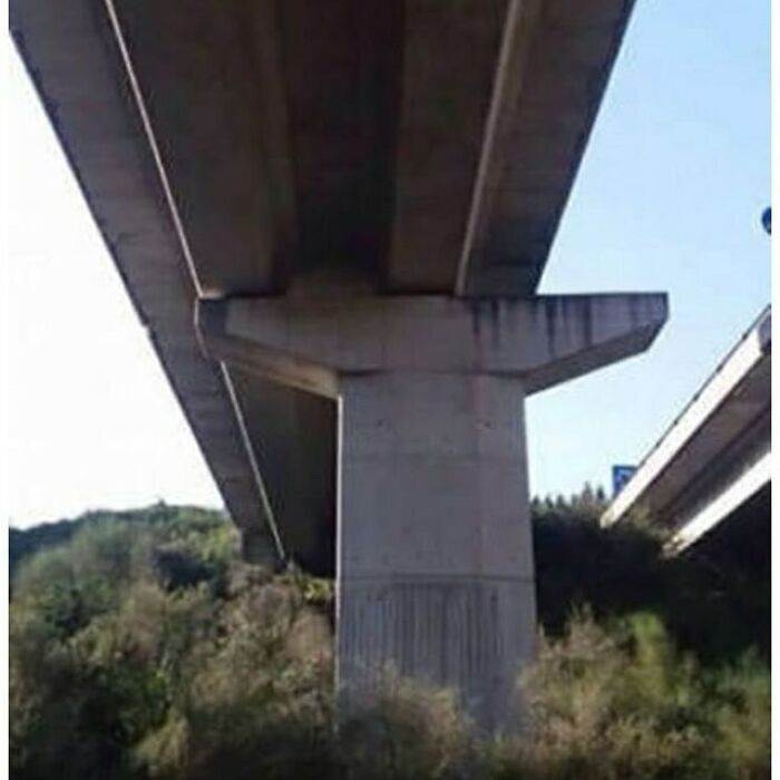 Misaligned highway overpass showcasing a funny construction error amid greenery.