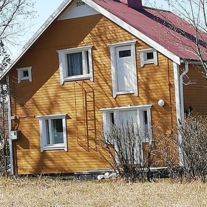 A house with a misplaced second-story door, highlighting a construction fail.