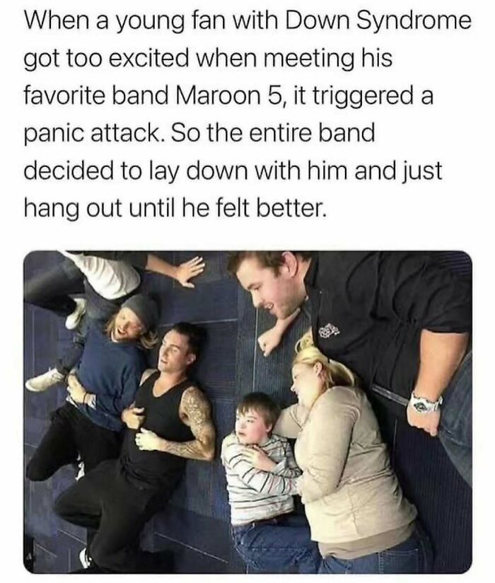 Band members and a young fan with Down Syndrome lying on the floor, showcasing wholesome kindness.